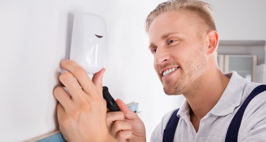 Man connecting a motion sensor in a living area